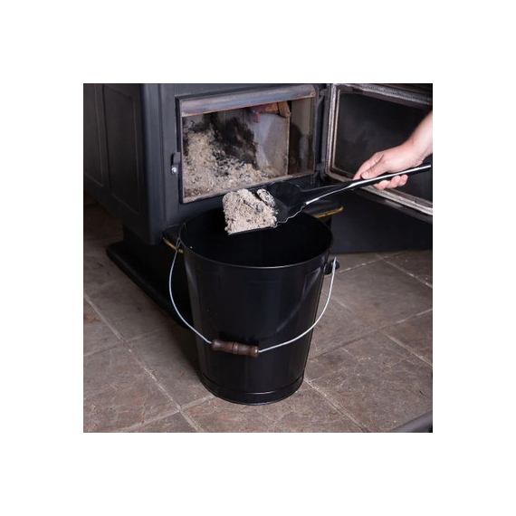 The ashes are putting on the black container using the black shovel to clean the fireplace.